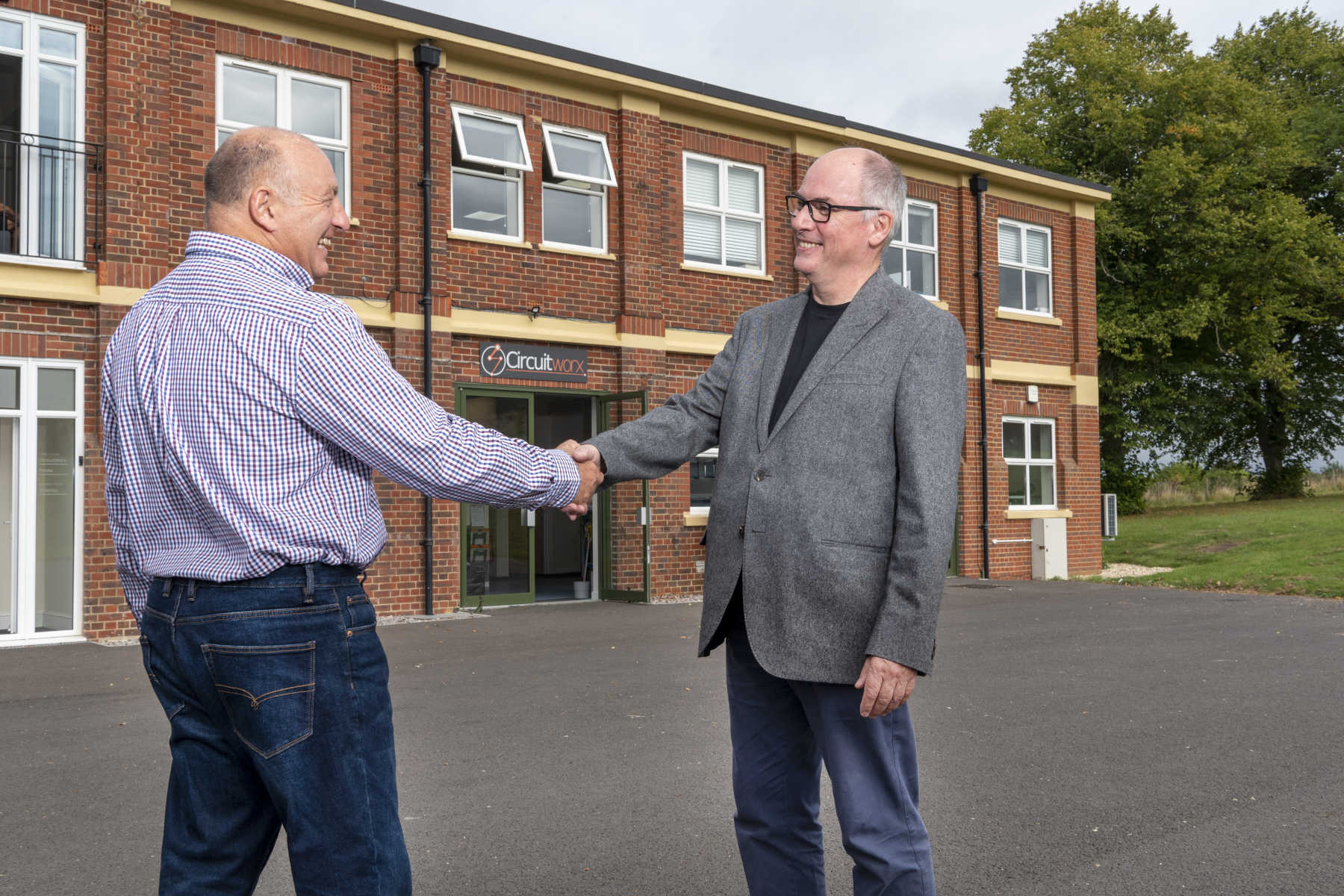 Account manager shaking hands with very happy Client outside CircuitWorx building