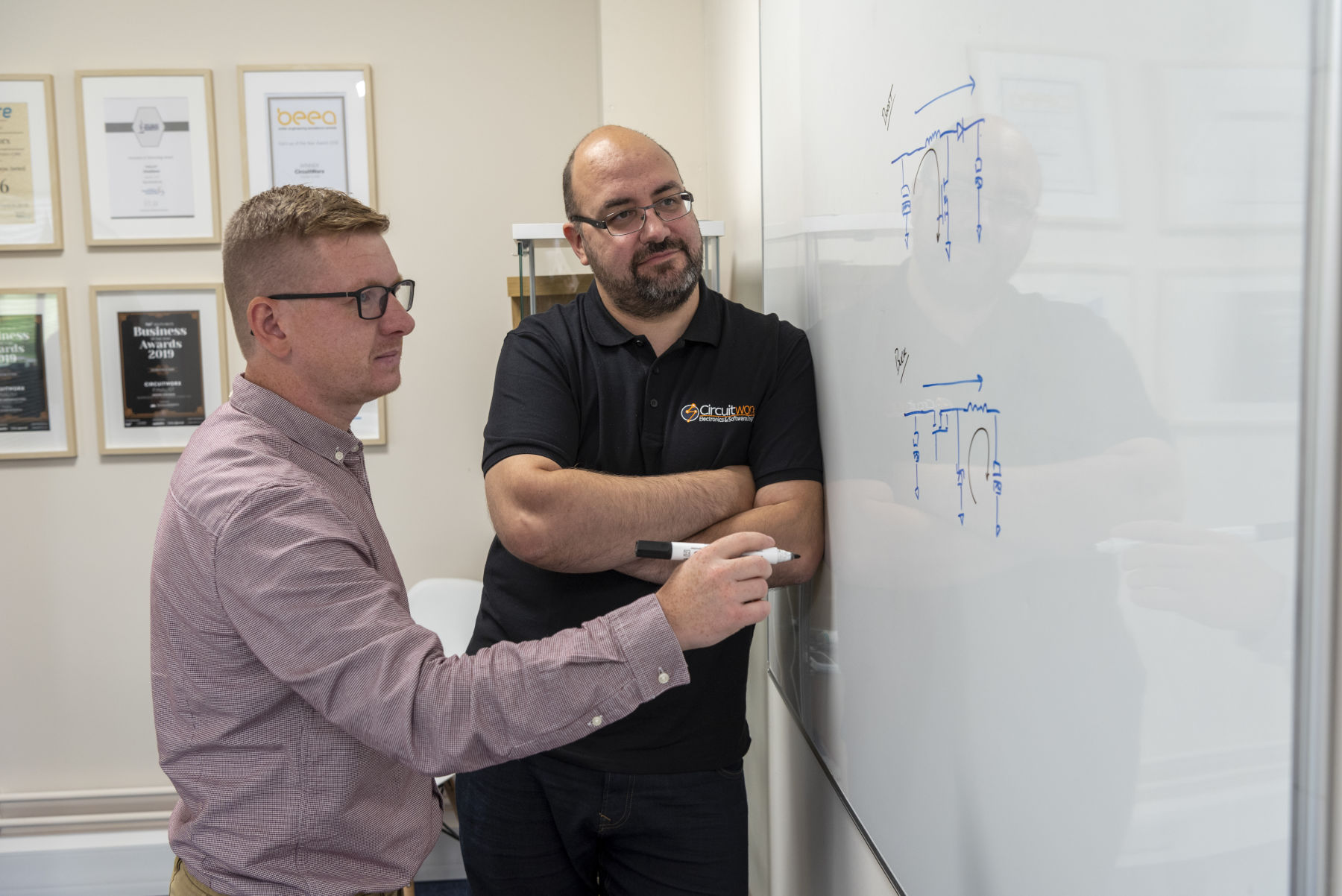 CircuitWorx Directors and Engineers discussing circuit design at whiteboard