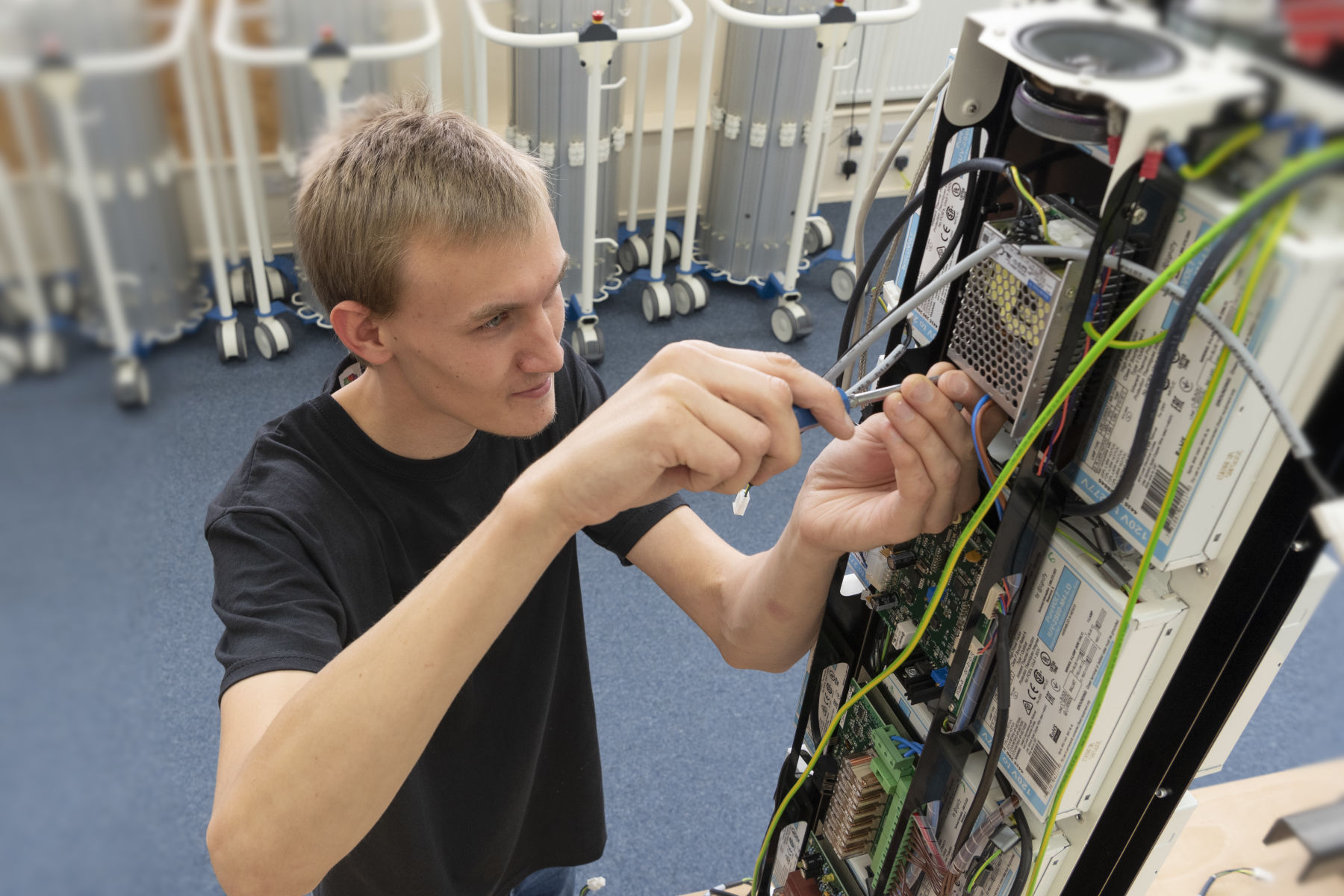 Technician assembling wiring harness and PCBs into mechanical enclosure