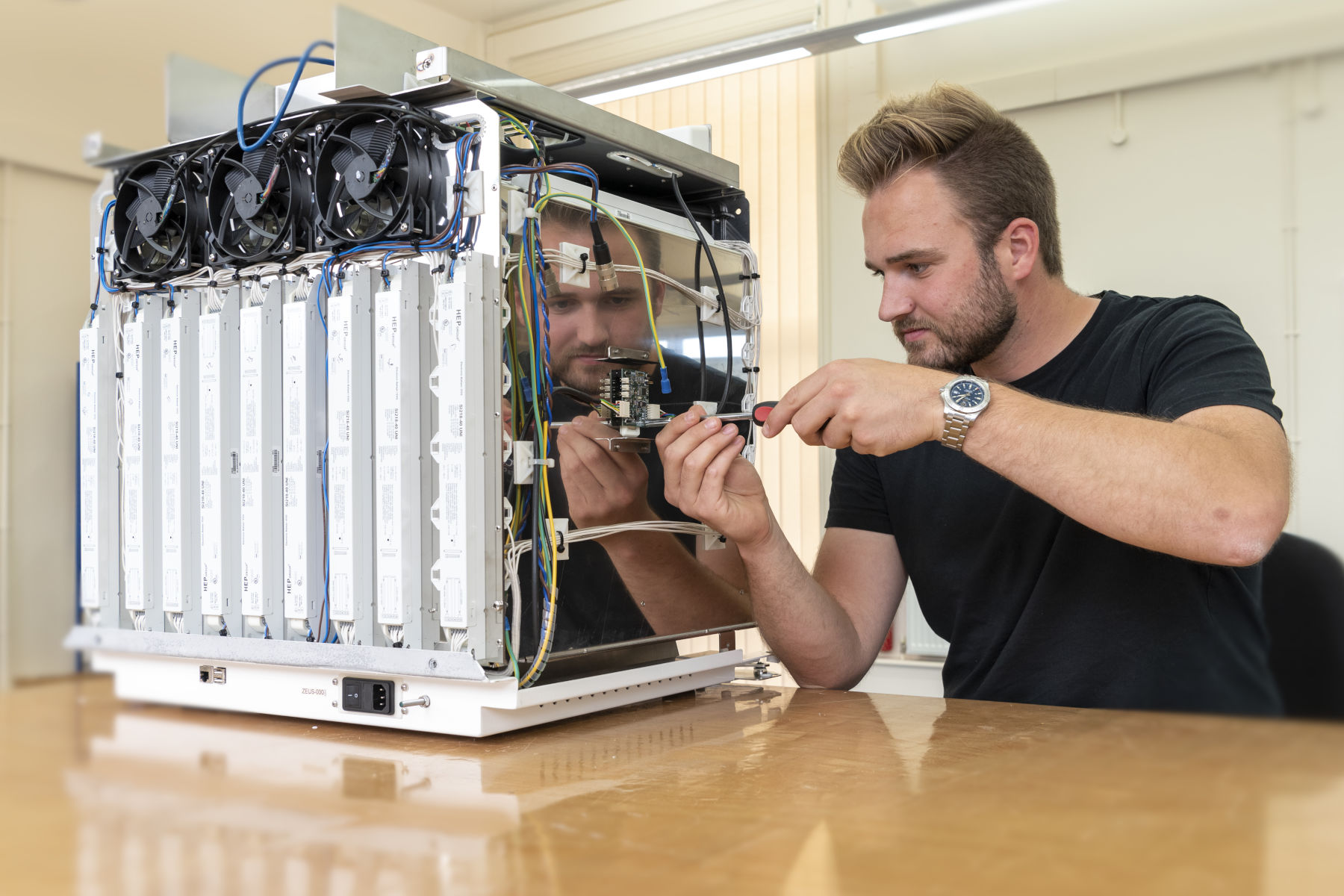 Engineer assembling PCBs into mechanical enclosure during box build