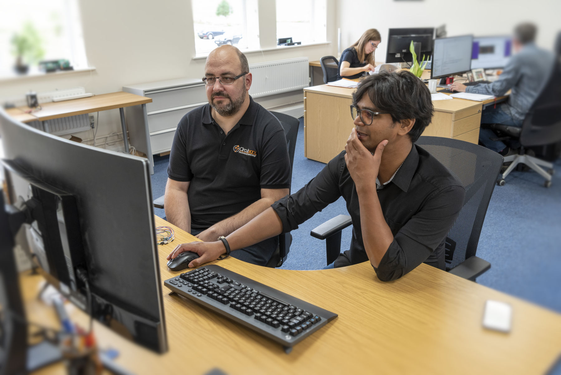 Engineers in CircuitWorx office reviewing electronics and software designs