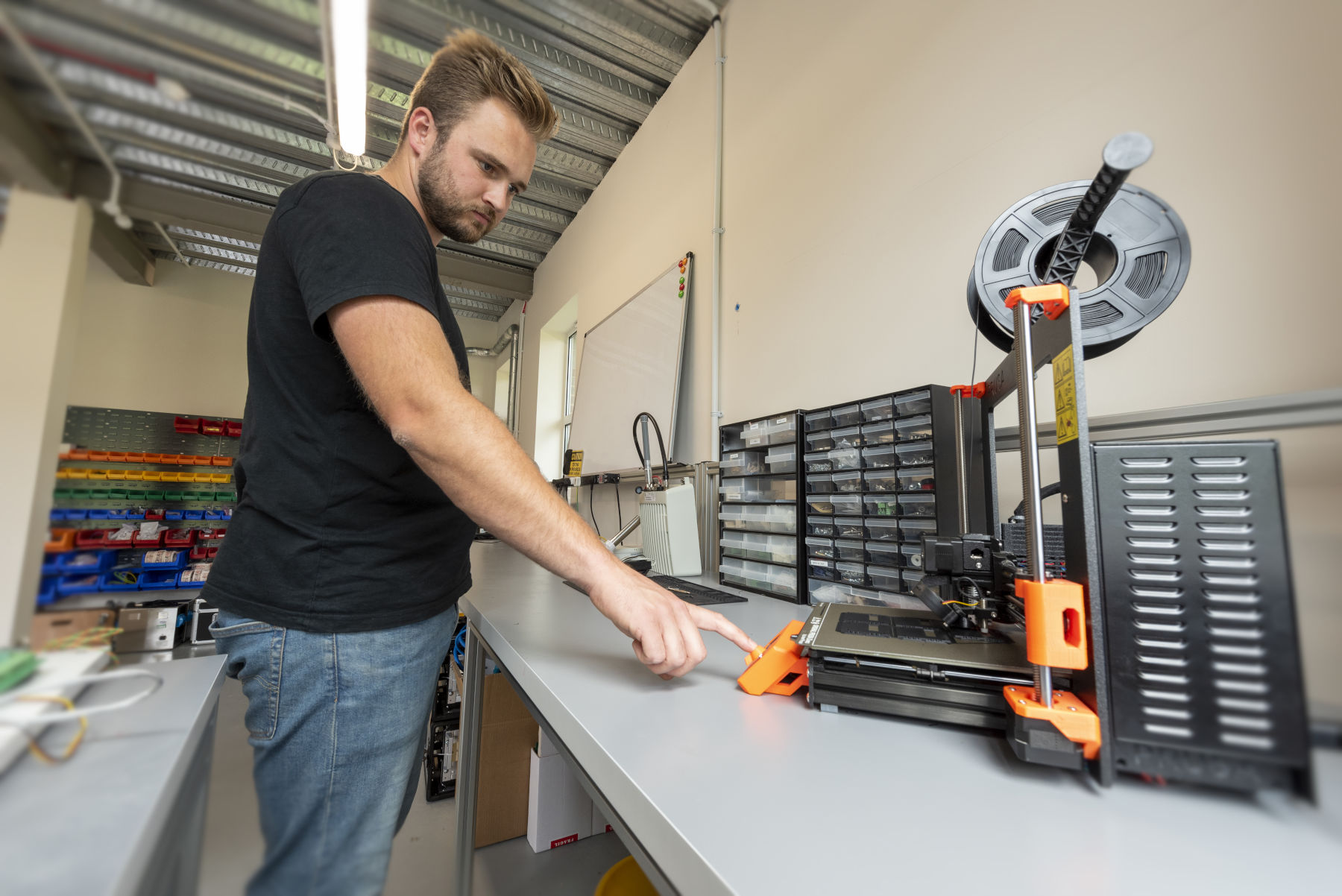 Engineer in workshop producing prototype parts using 3D printer