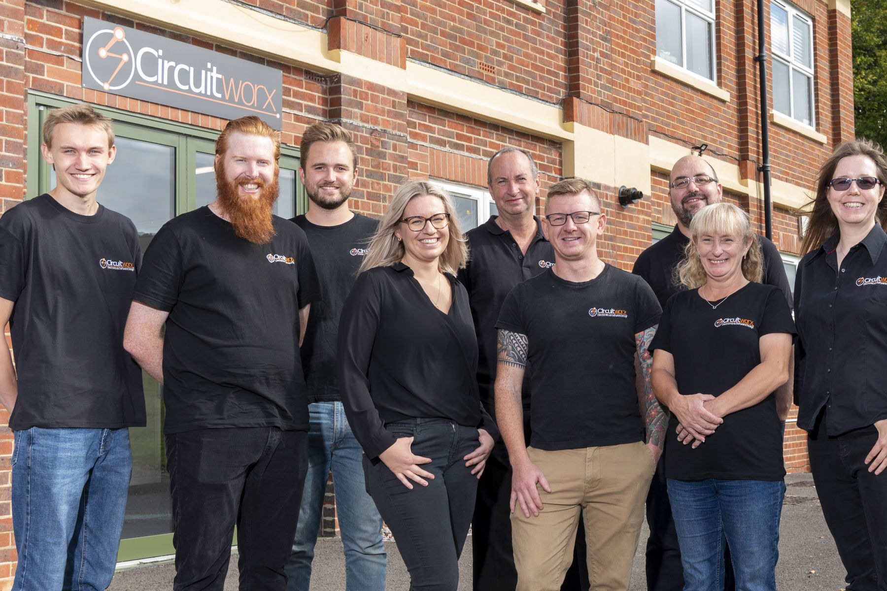 Outdoor shot of CircuitWorx engineers and technicians in front of brick building