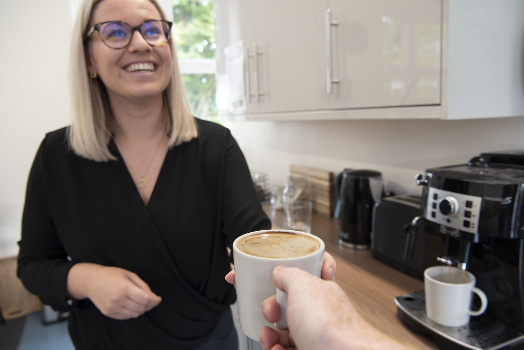 CircuitWorx office manager smiling and handing over a cup of coffee